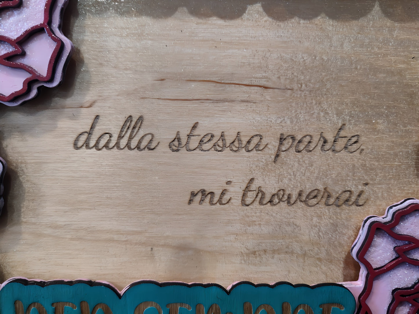 Wooden plaque with Italian engraved text and pink floral decorations