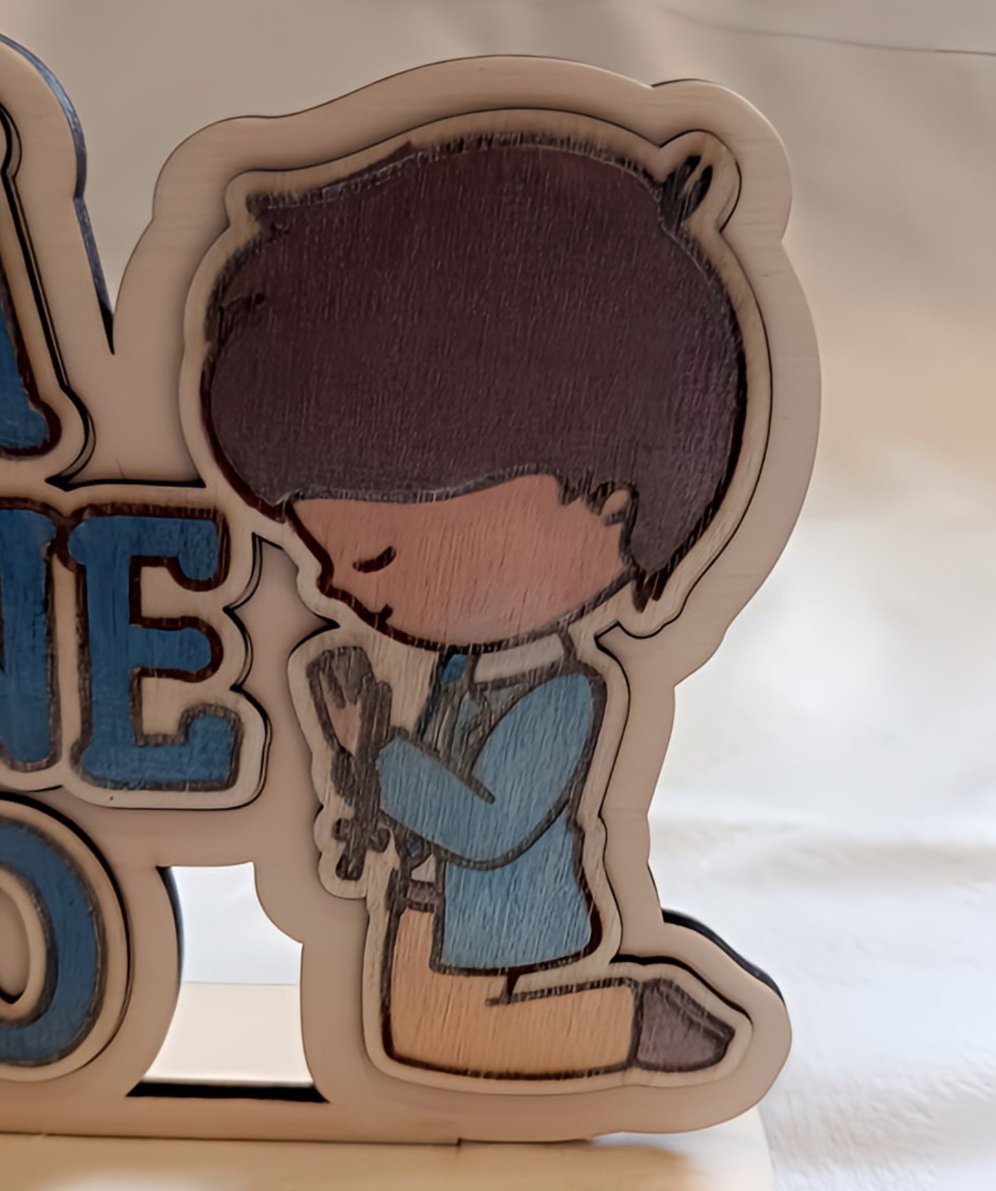 Cartoon boy kneeling and praying, wooden decor with blue jacket and cross