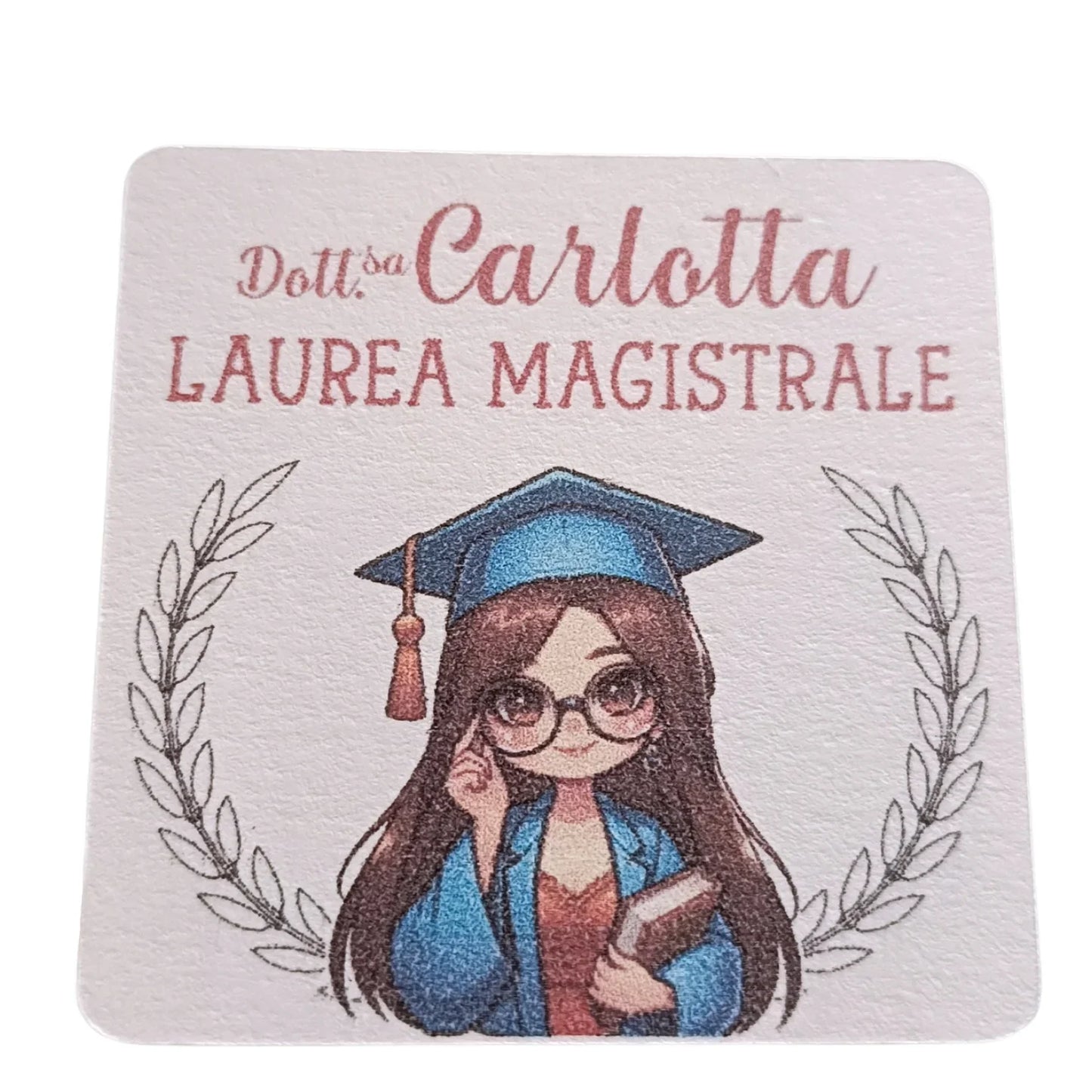 Cartoon graduate girl with glasses in cap and gown, holding a book, laurea magistrale sign