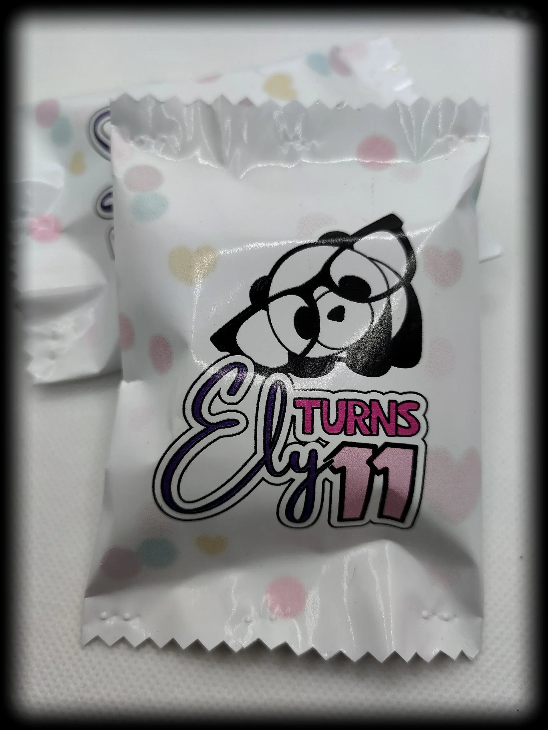 Custom party candy wrapper with cartoon bear and text 'Ely turns 11' on pastel polka dot background