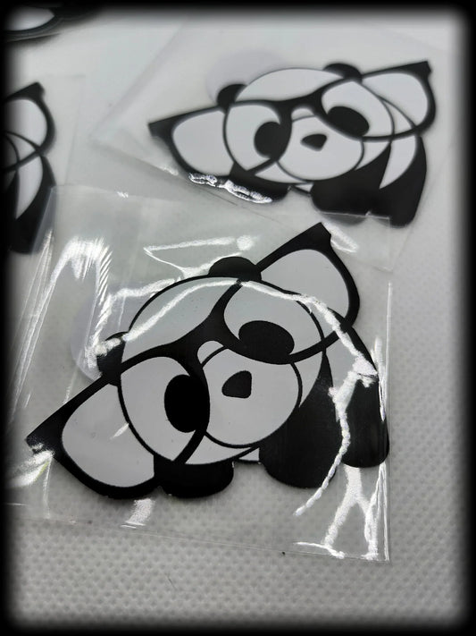 Black and white cartoon panda stickers on textured white surface in plastic sleeves