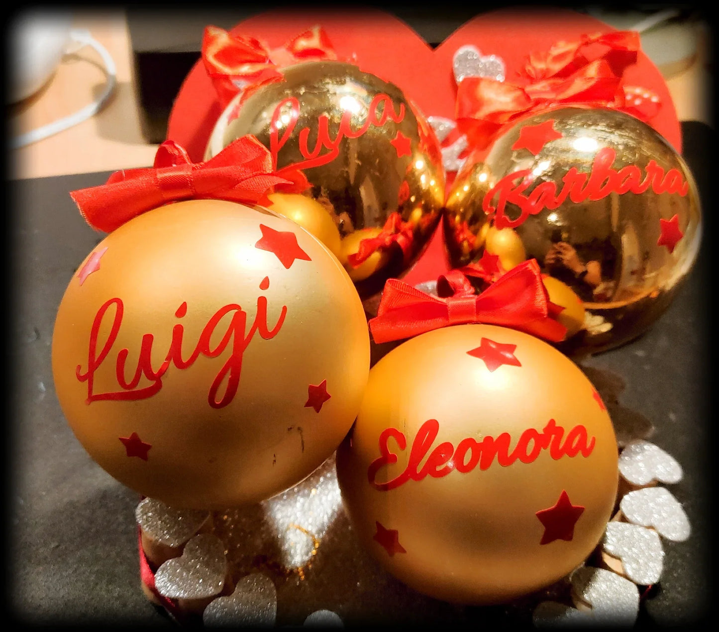 Personalized gold and bronze Christmas ornaments with red names and bows