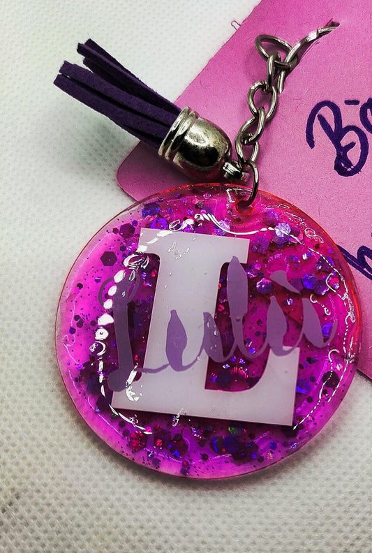Pink glitter resin keychain with purple tassel and large white L initial charm