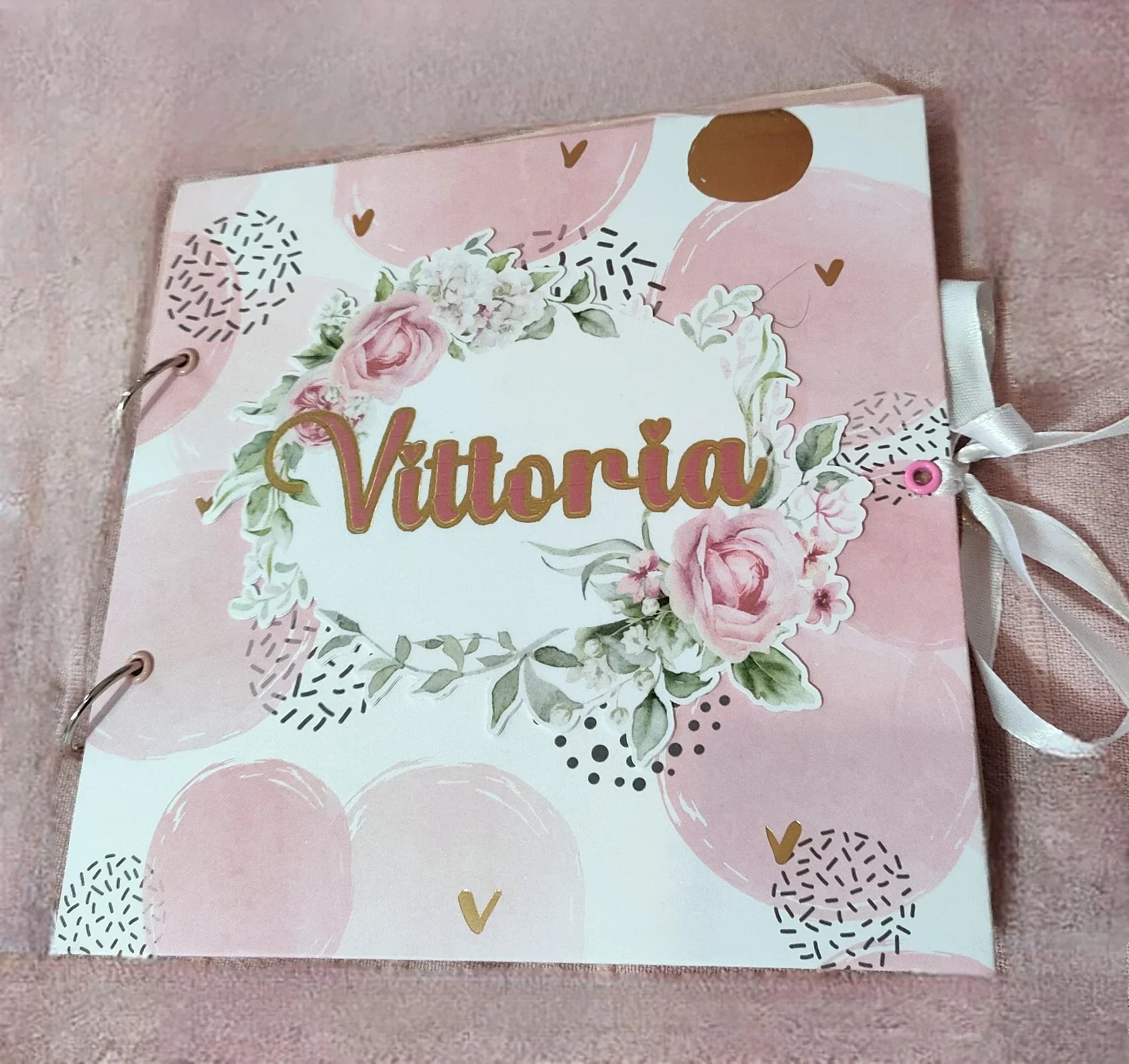 Personalized pink floral scrapbook with 'Vittoria' on cover, pink background, ribbon closure