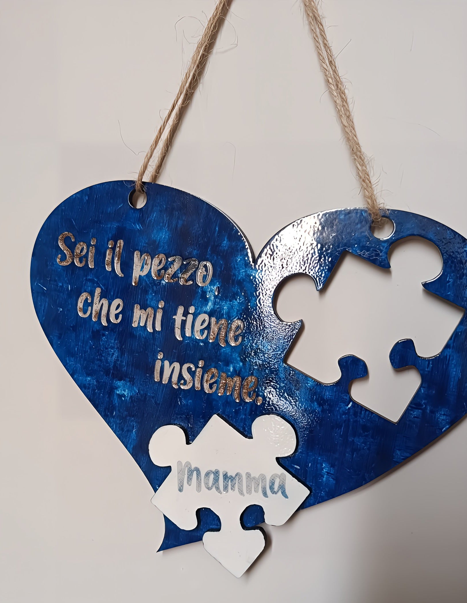 Blue heart-shaped wooden sign with Italian text, puzzle piece for 'Mamma', on a rope.