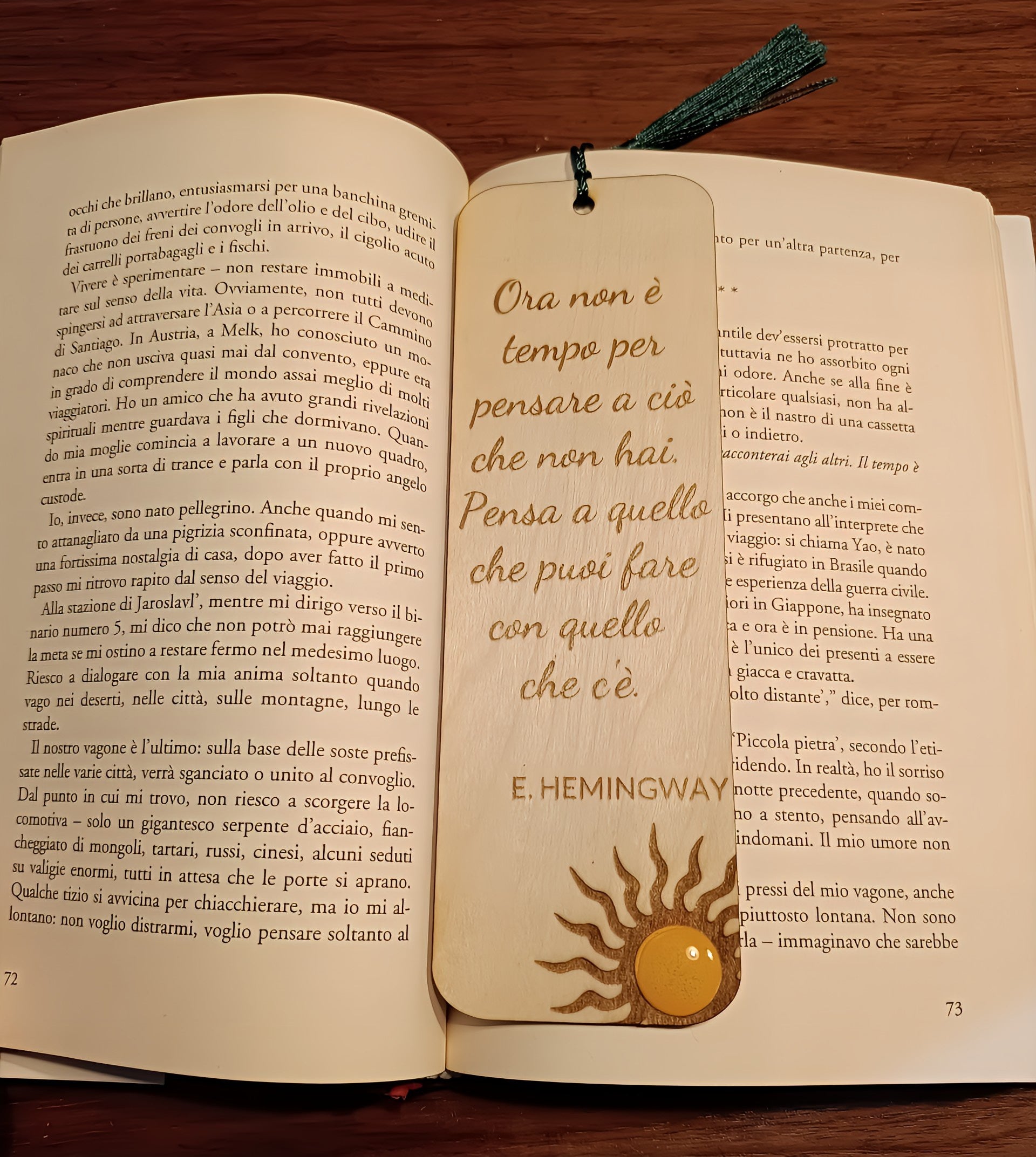 Wooden Hemingway quote bookmark with sun design inside open Italian book on wooden table