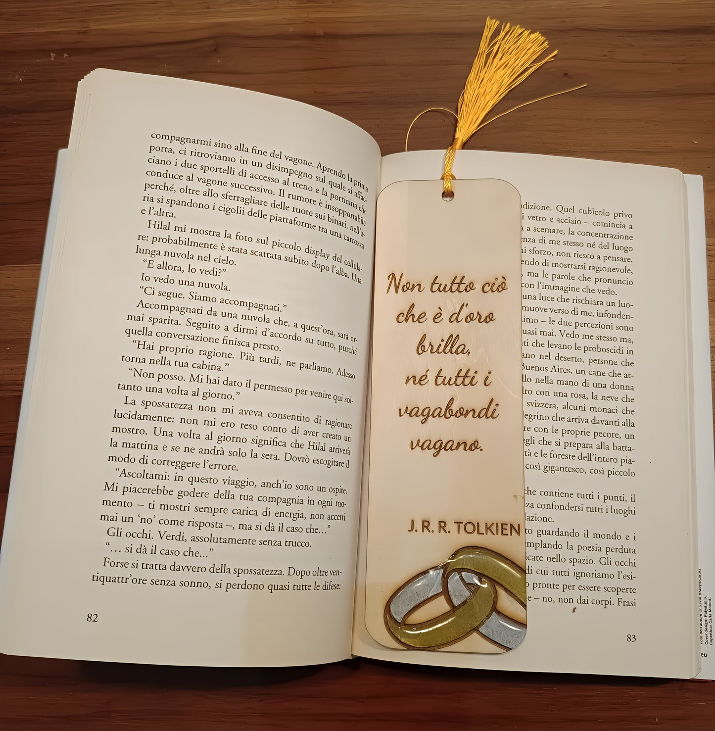 Italian book open with a J.R.R. Tolkien quote bookmark and gold tassel on wooden table