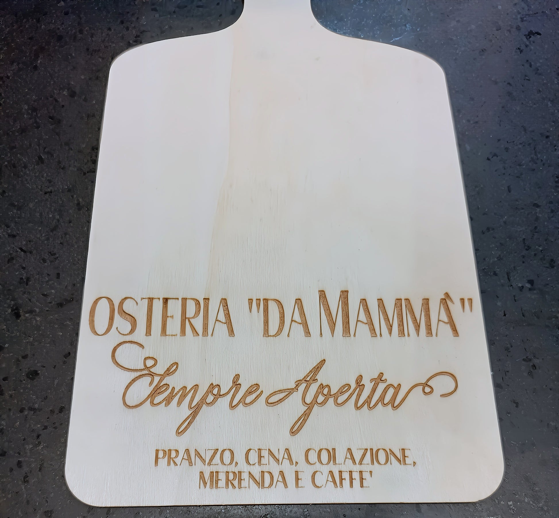 Osteria 'Da Mammà' engraved wooden pizza board on dark stone countertop