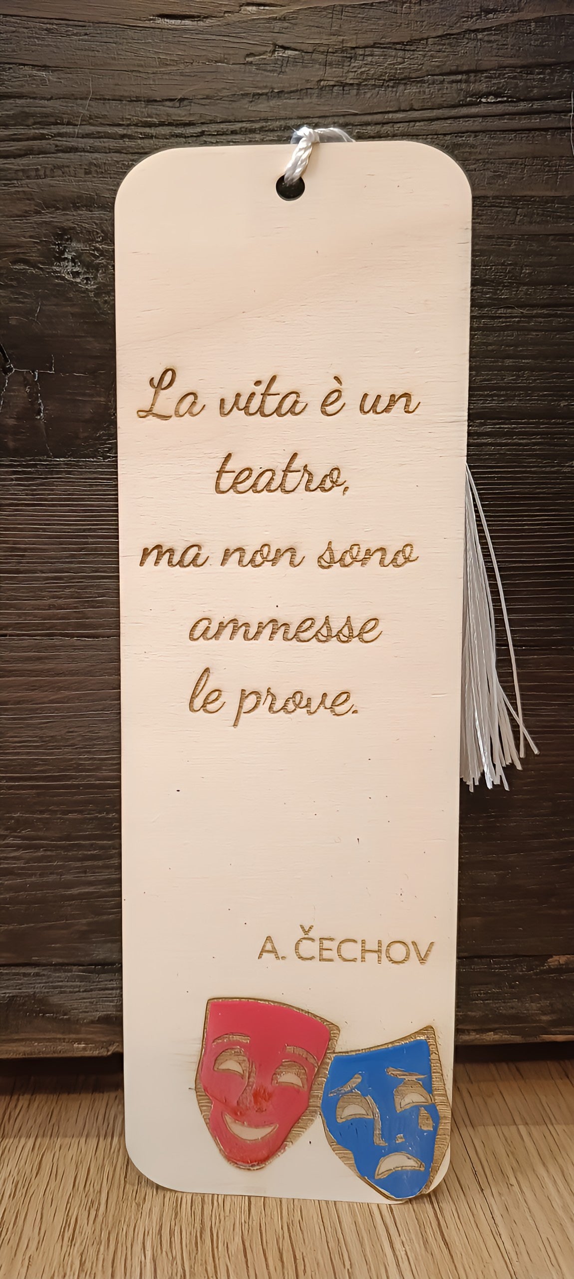 Engraved wooden bookmark with Italian quote, comedy and tragedy masks, rustic background