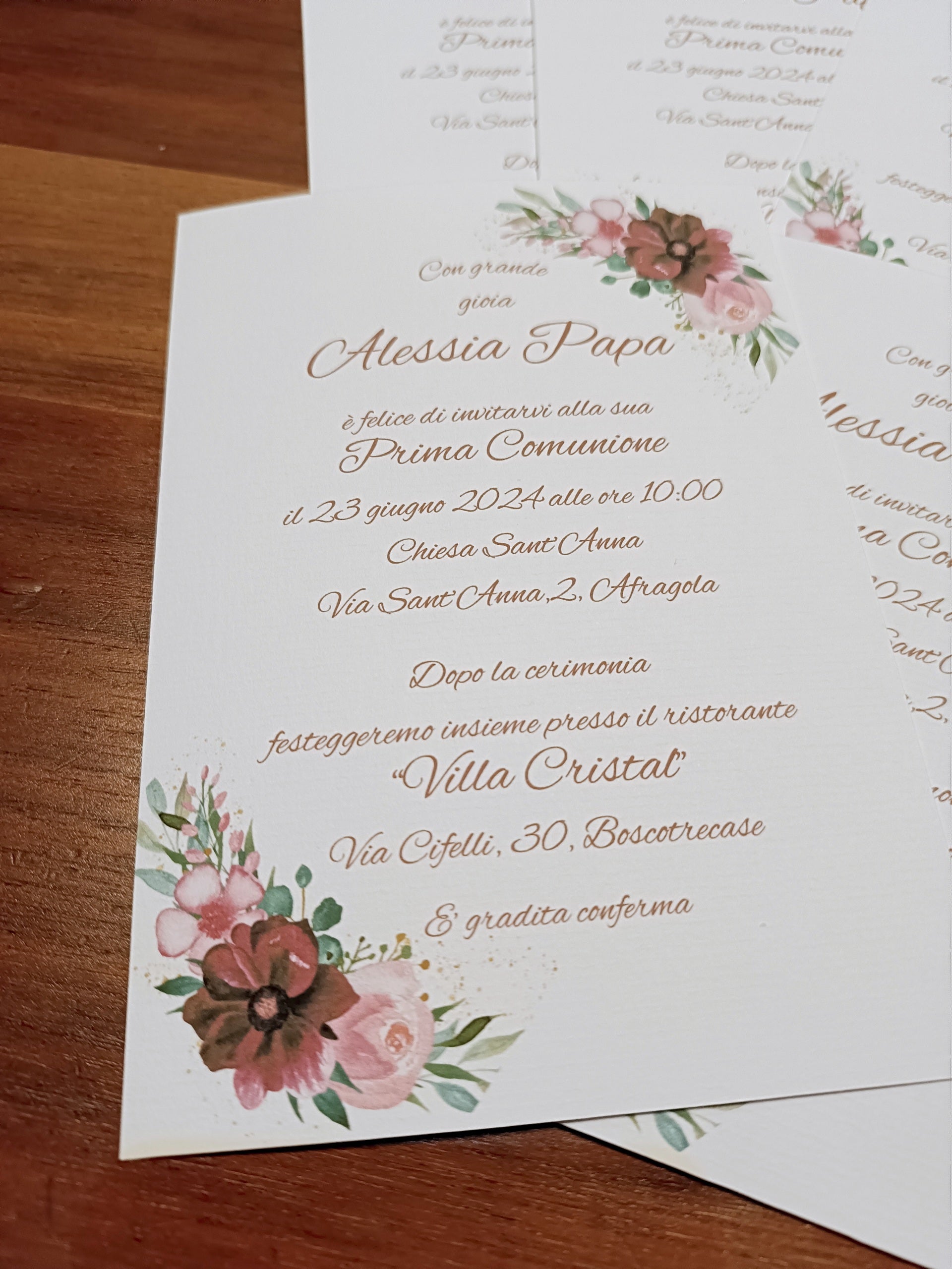 Italian First Communion invitation card with floral design on wood table