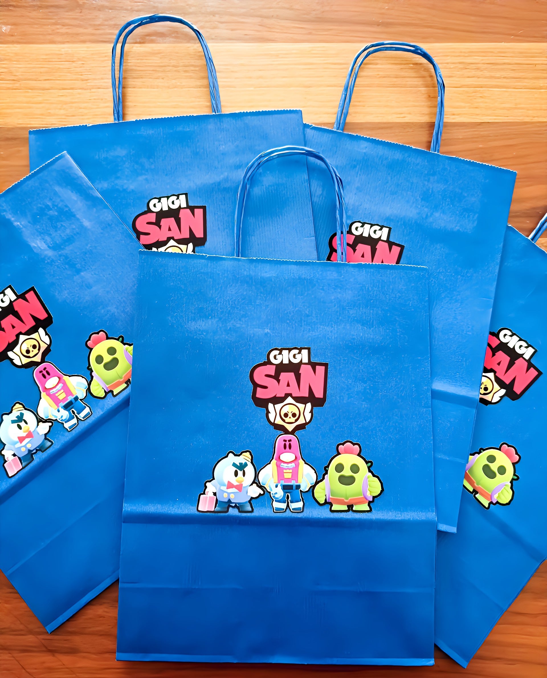 Blue Gigi San party bags with cartoon characters on wood background