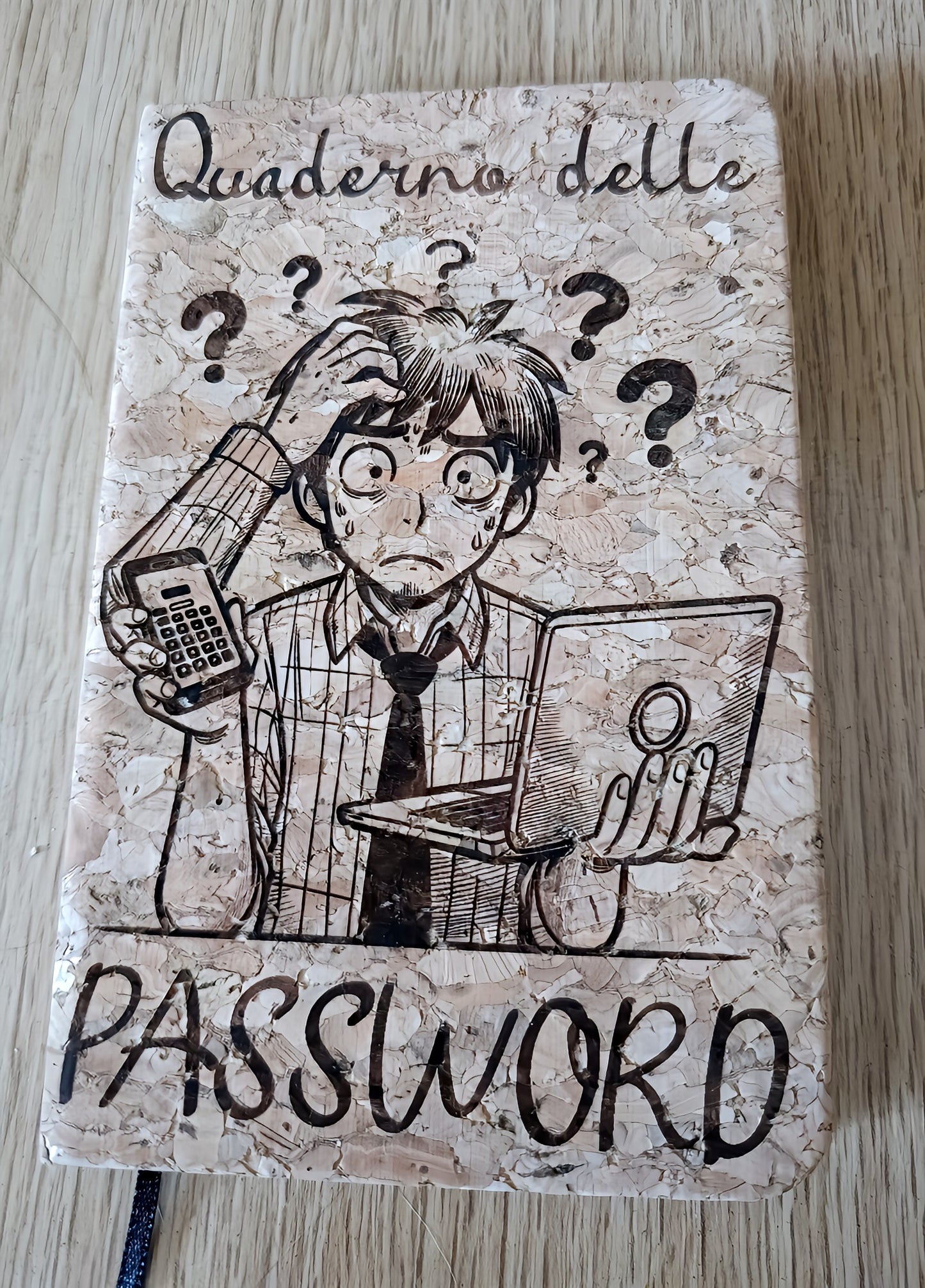 Notebook cover with comic-style confused man, laptop, phone, labeled 'Quaderno delle PASSWORD'