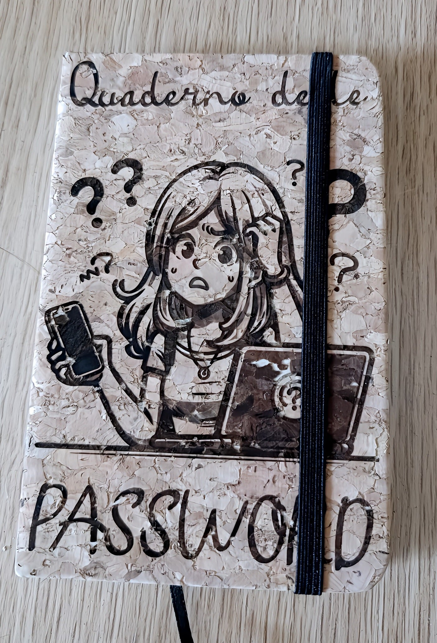 Notebook with cork cover, comic girl illustration, 'Quaderno delle Password' text, question marks