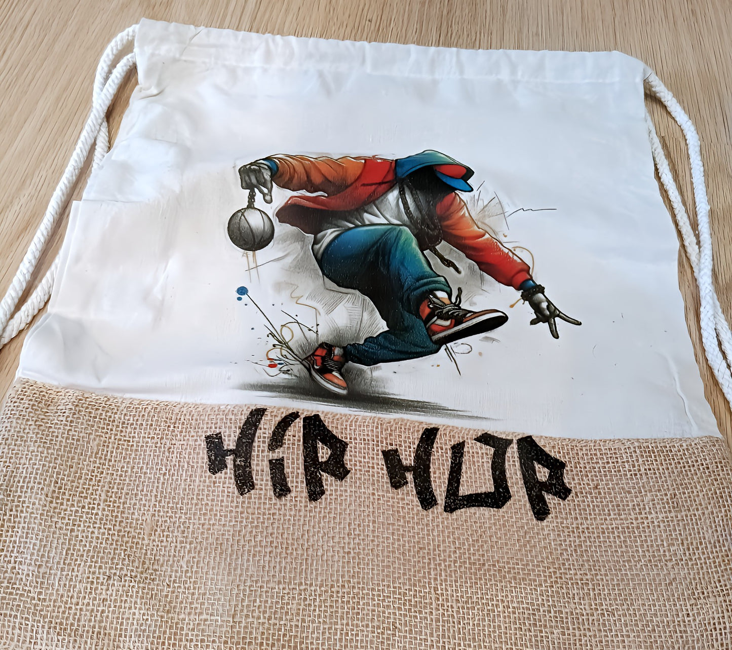 Hip hop drawstring bag featuring breakdancer illustration on white and burlap fabric