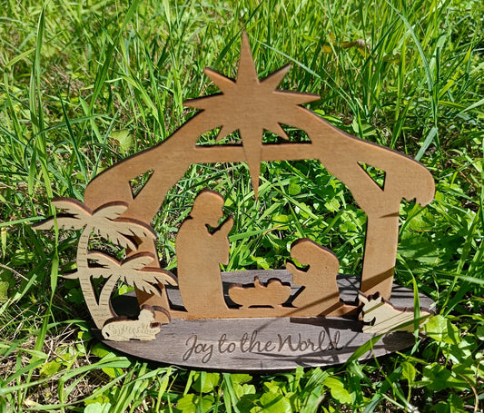 Wooden nativity scene 'Joy to the World' on green grass, outdoor Christmas decoration