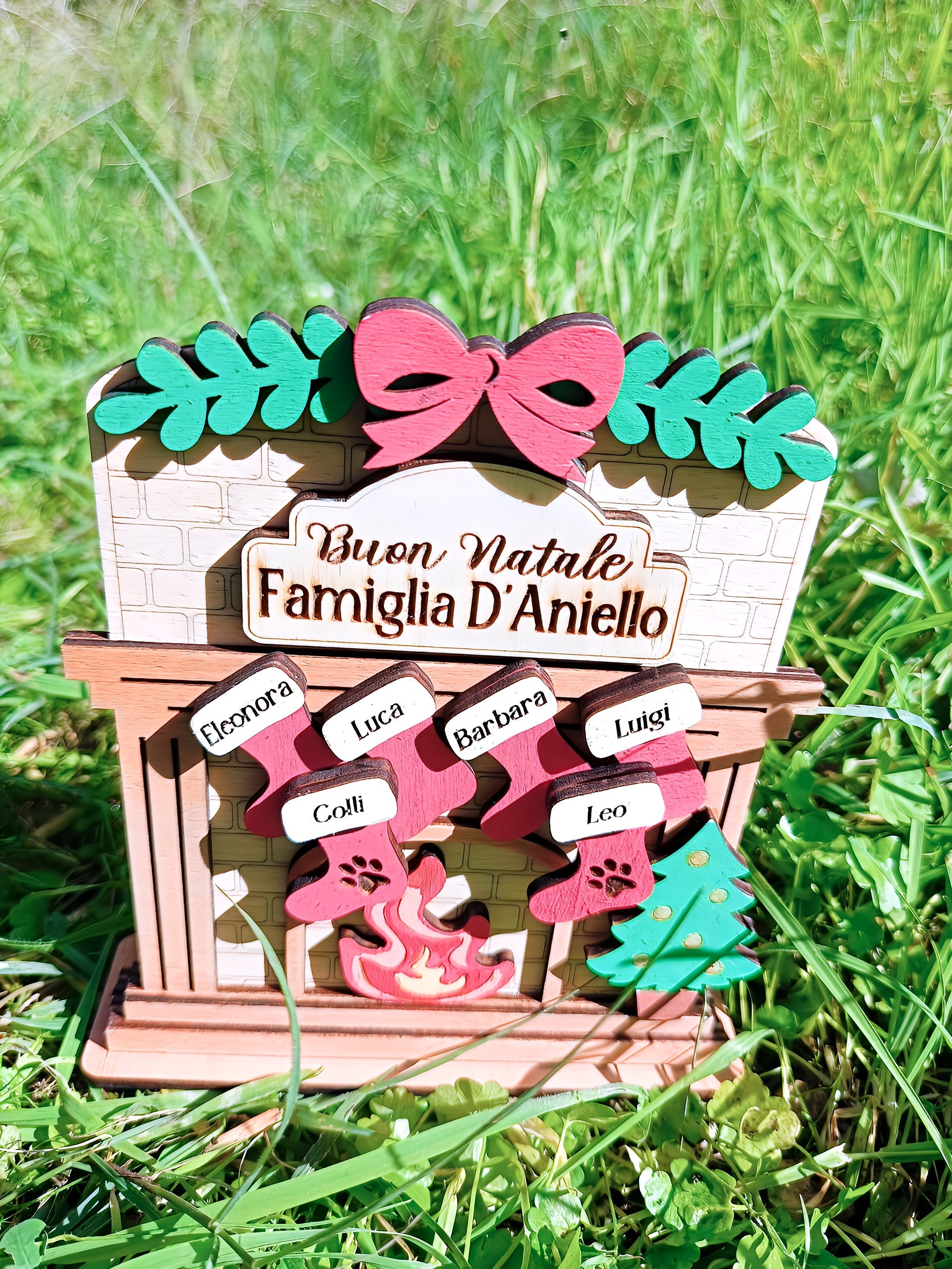 Personalized Christmas wooden fireplace ornament with family names in grass outdoors