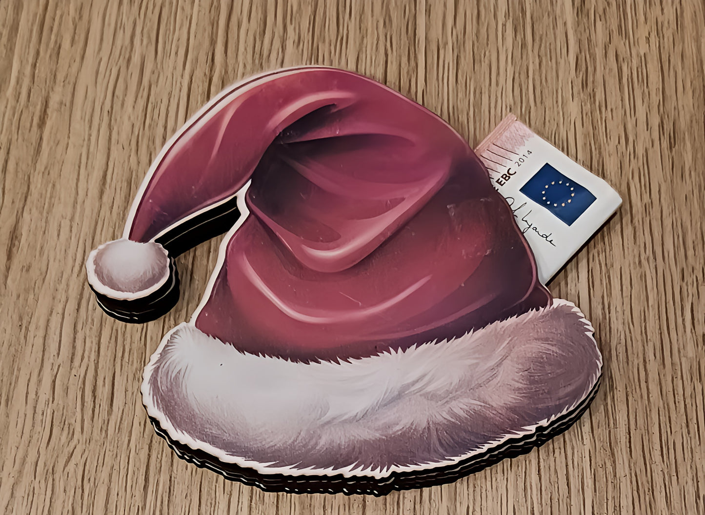 Santa hat sticker on wood table with EU ID card partially visible