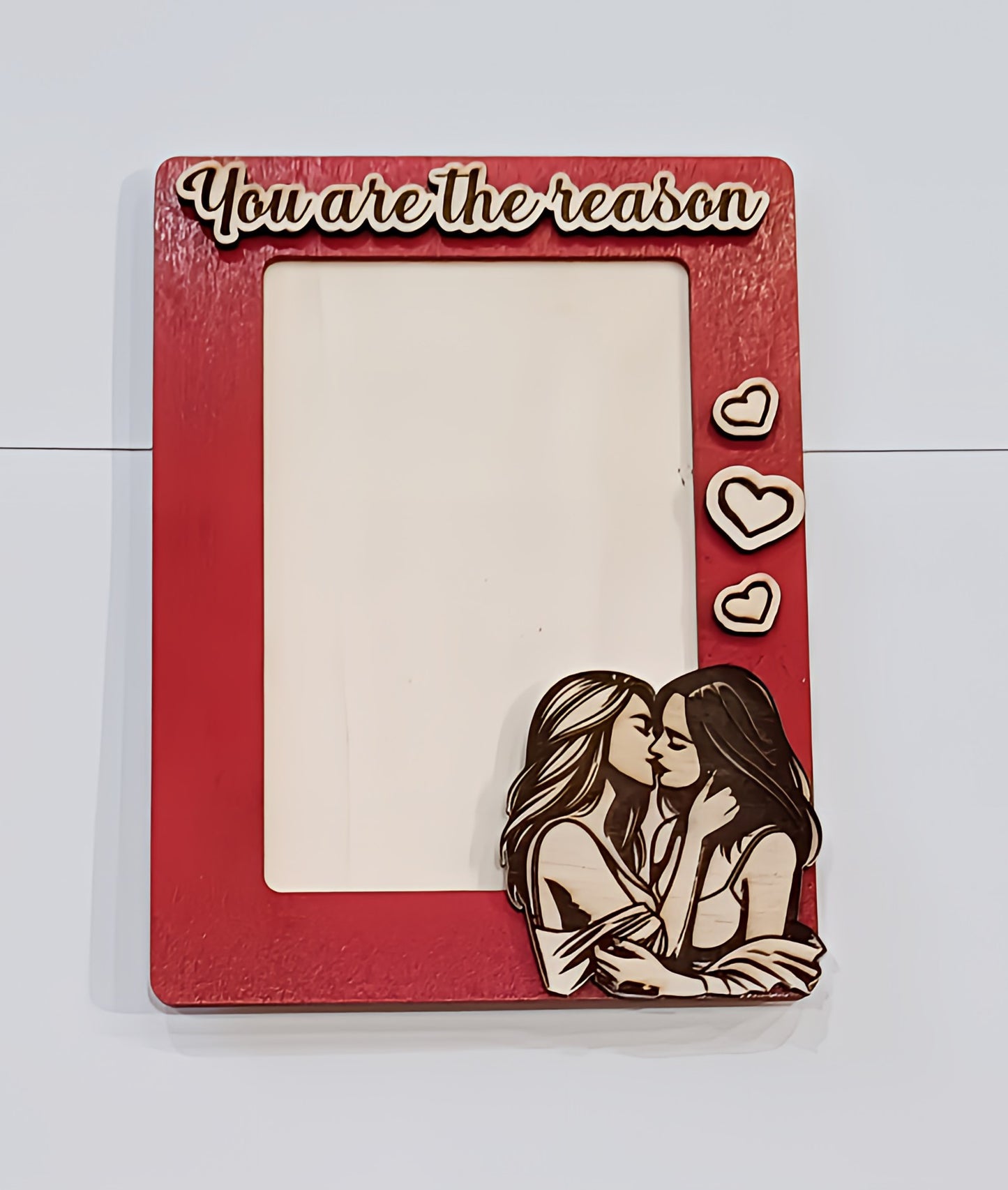 Red picture frame with 'You are the reason', hearts, and two women kissing illustration