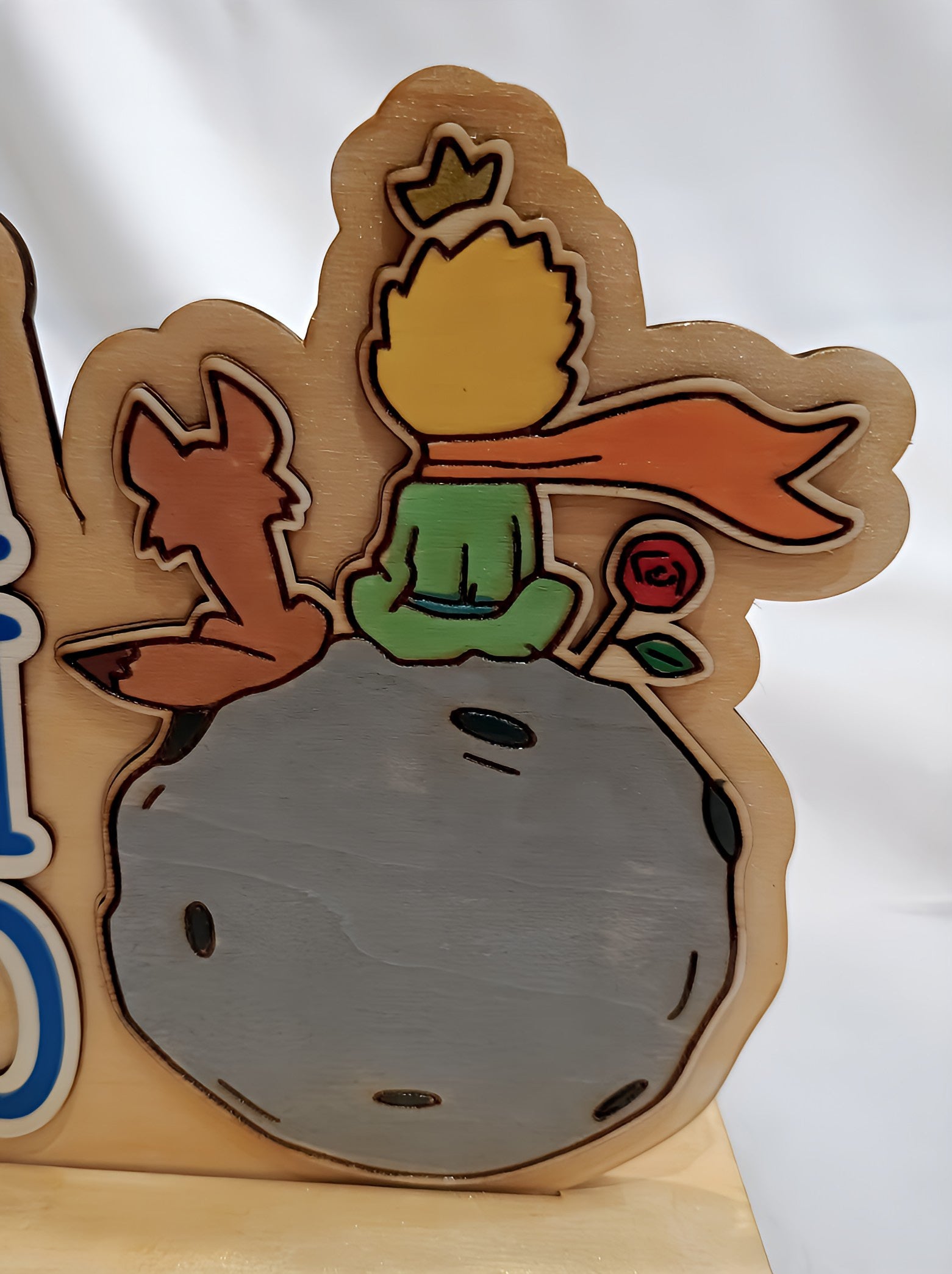 Wooden plaque of Little Prince, fox, and rose on asteroid with white background