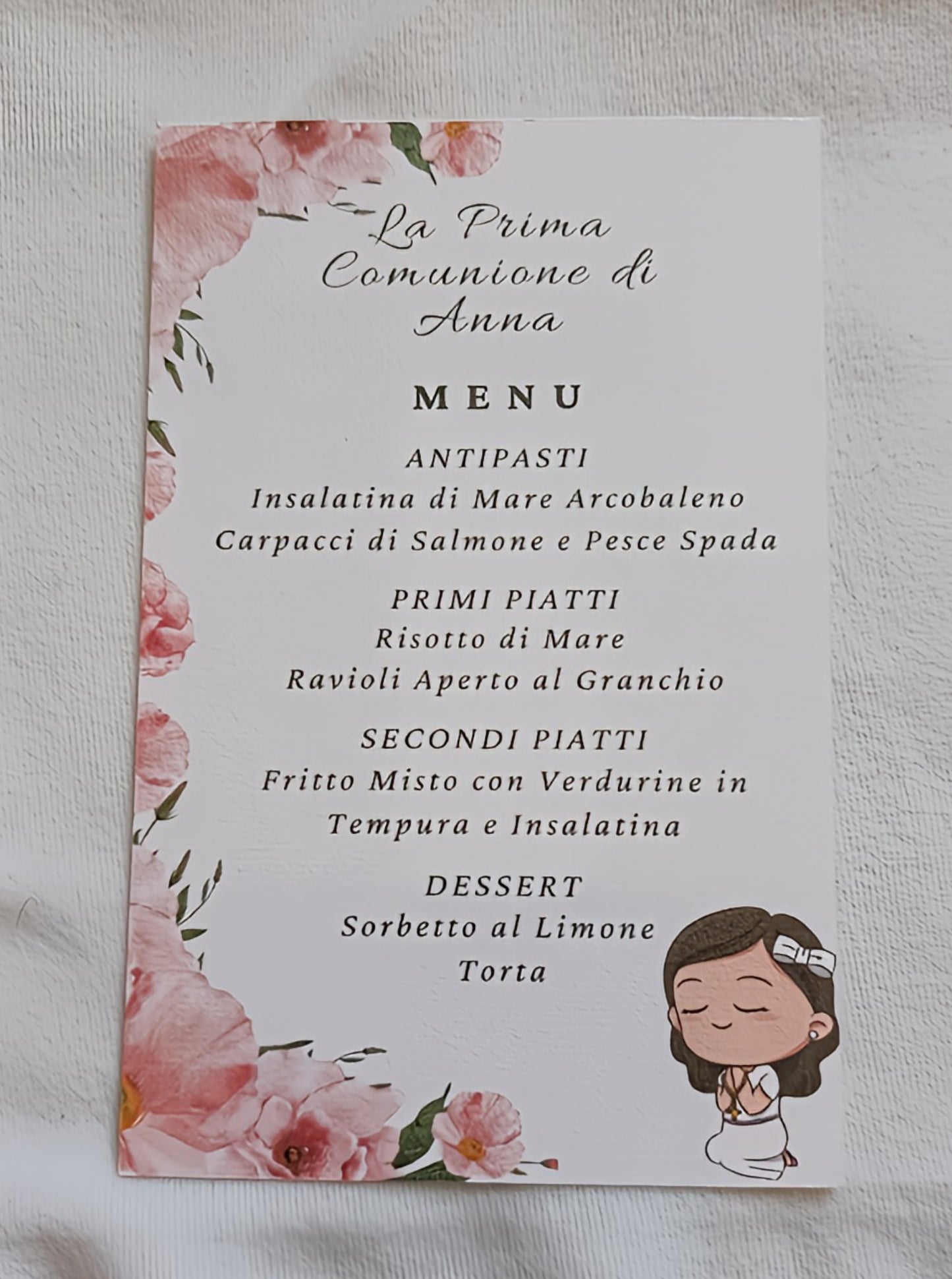 Italian First Communion menu card with pink floral border and cartoon girl praying illustration