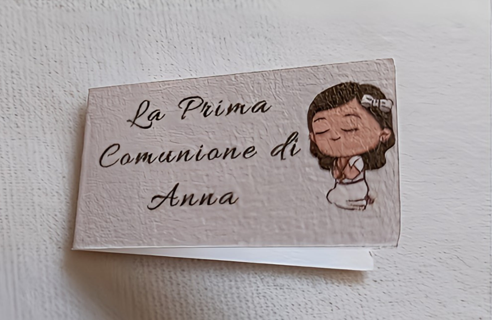 First Communion invitation card with cartoon girl and the text 'La Prima Comunione di Anna'.
