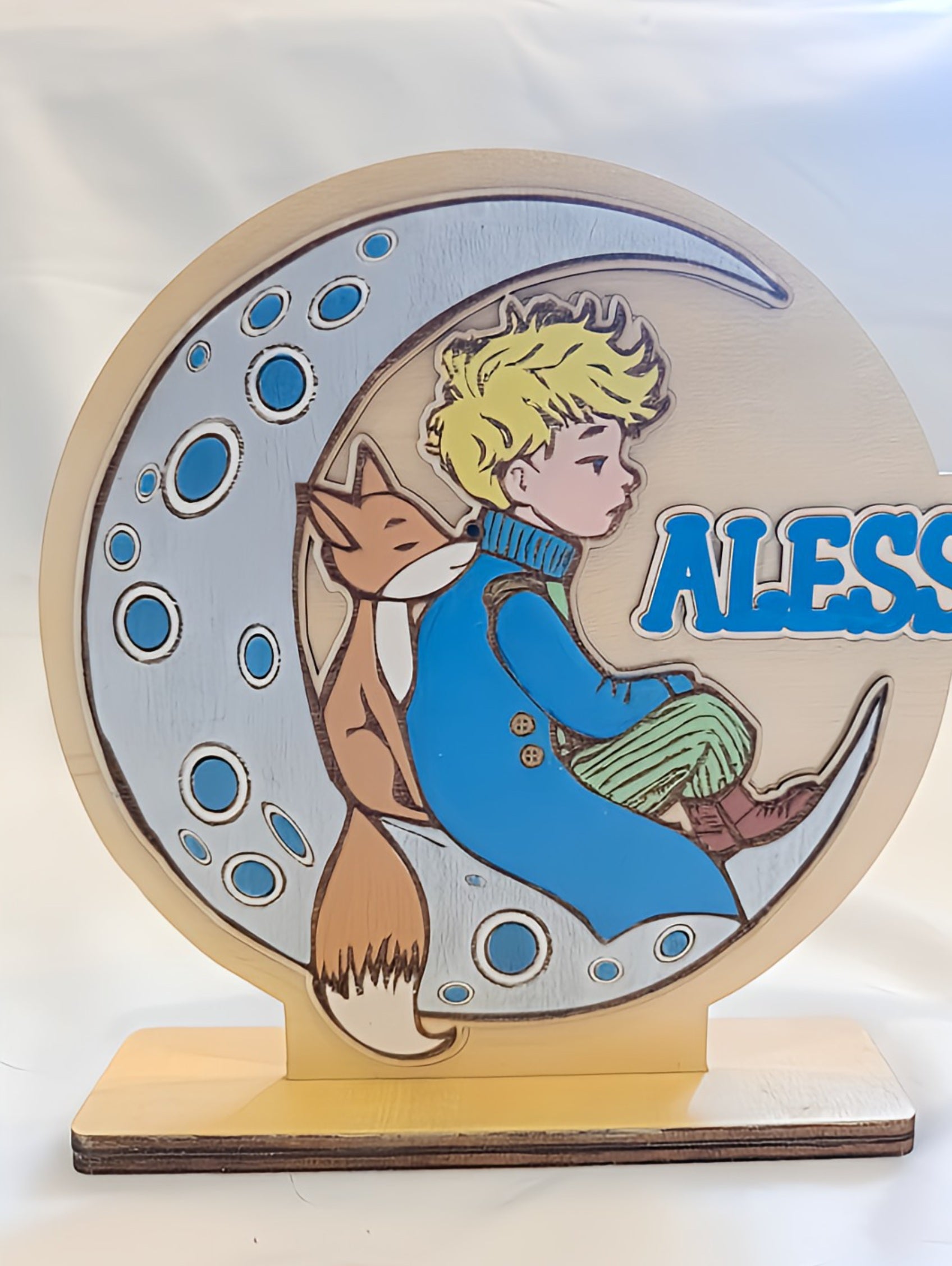Wooden plaque of a boy with blond hair and a fox on a crescent moon, name Aless on side