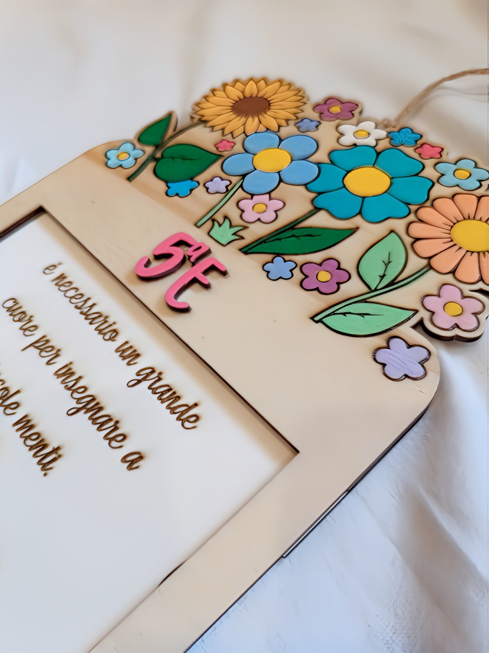 Wooden plaque with colorful flowers, '5ª E' text, and Italian inspirational quote.
