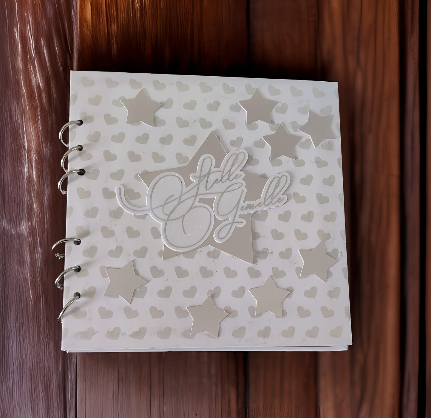 Handmade scrapbook with heart and star patterns, 'Hello Gemelle' text on wood background