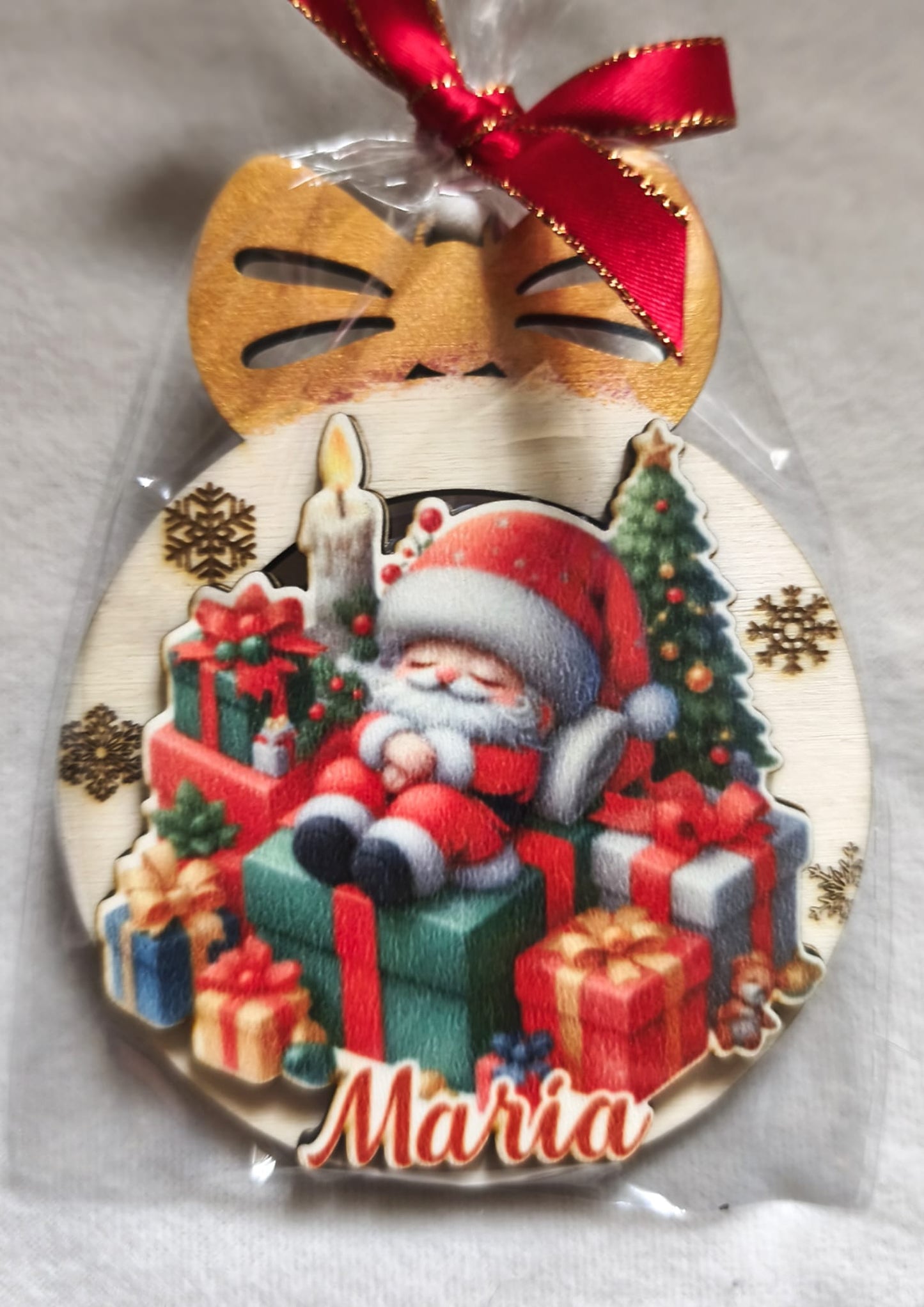 Personalized wooden Christmas ornament with Santa Claus, gifts, candle, and red ribbon.