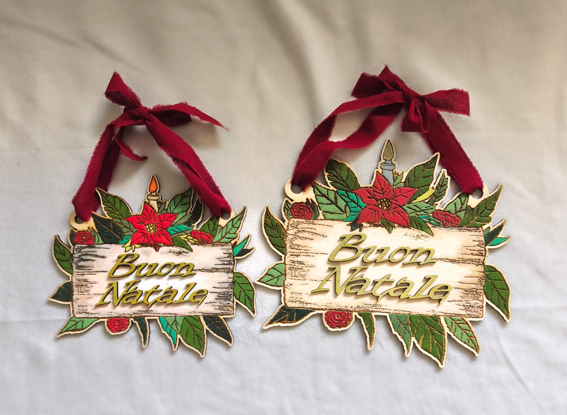 Buon Natale Christmas wooden signs with poinsettias, candles, and red ribbon on white background
