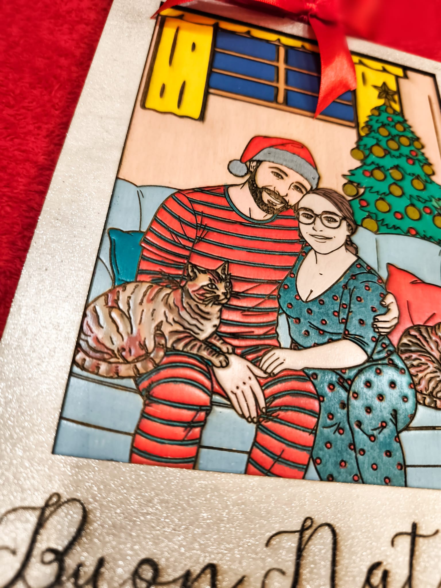 coppia in abiti natalizi seduta su divano con gatti