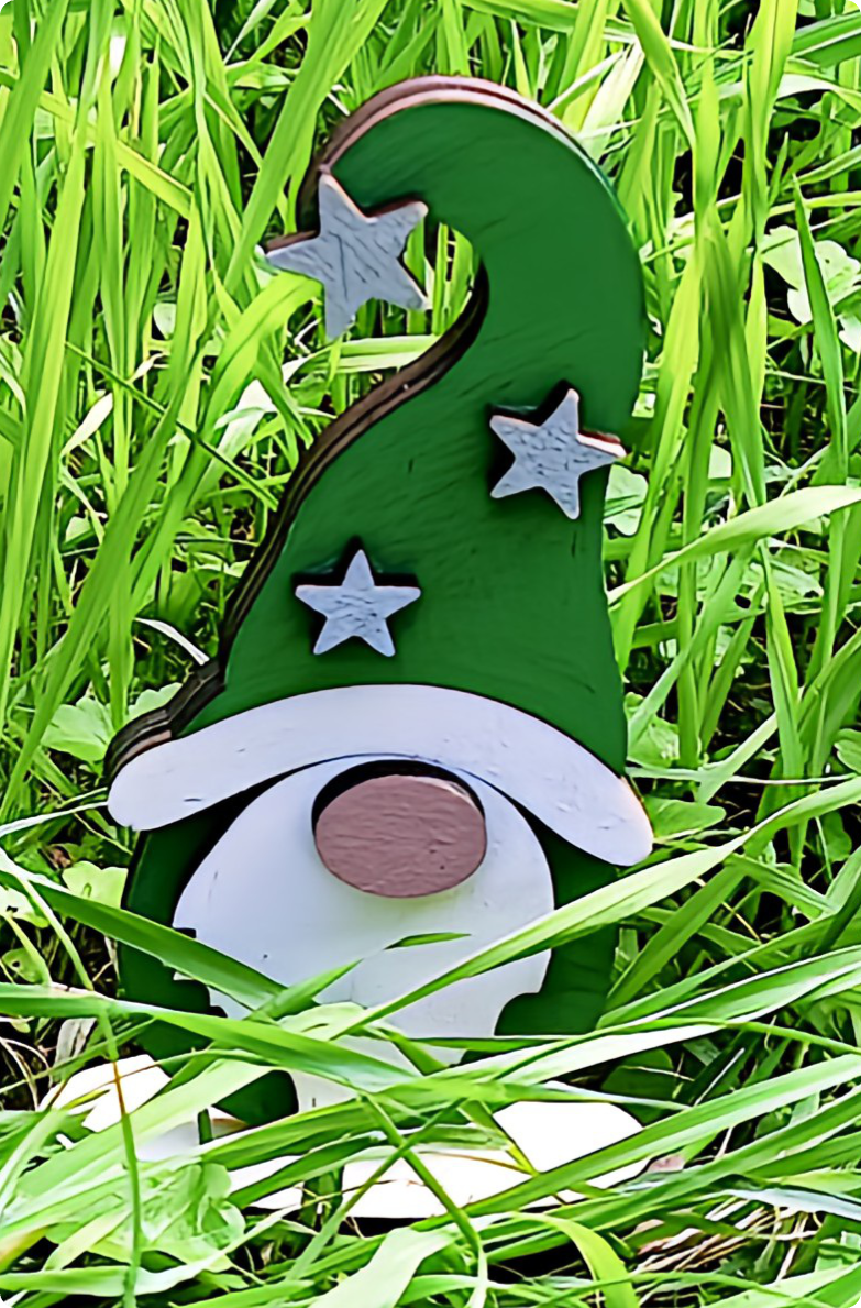 Wooden garden gnome with green hat and white stars among green grass outdoors