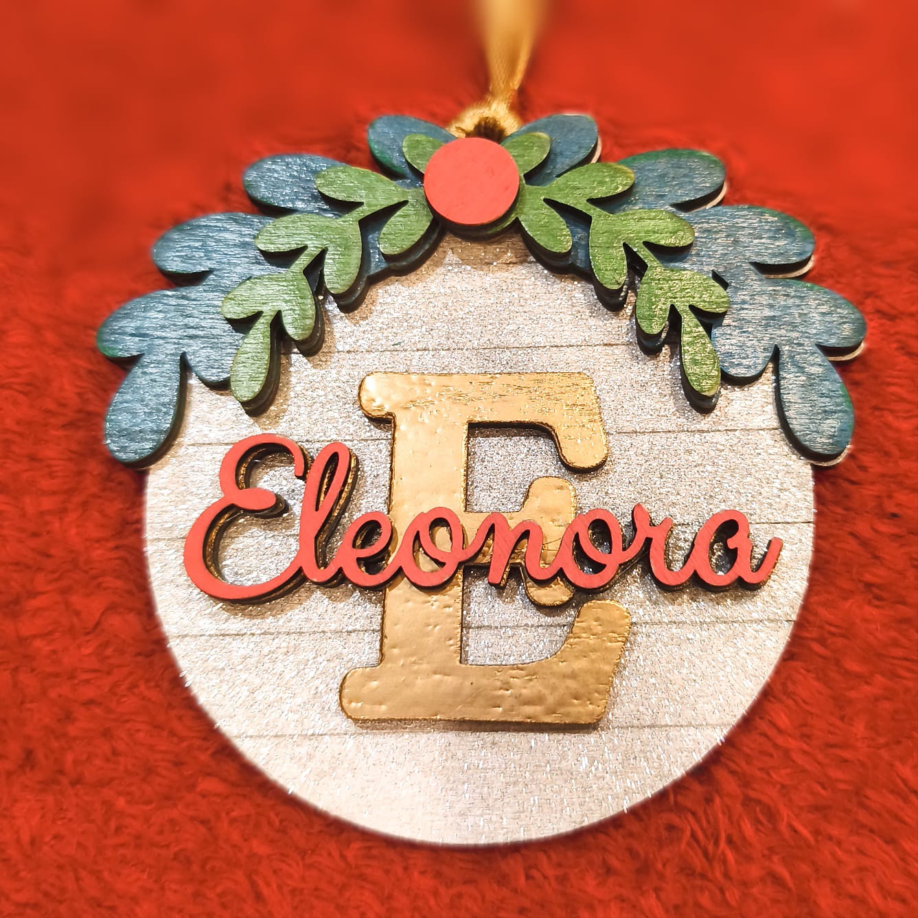 Ornamento natalizio artigianale legno con nome Eleonora, iniziale E dorata e nastro color oro per appendere