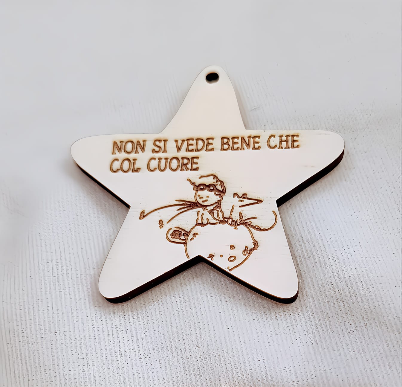 Wooden star ornament with Italian phrase and engraved child riding a planet