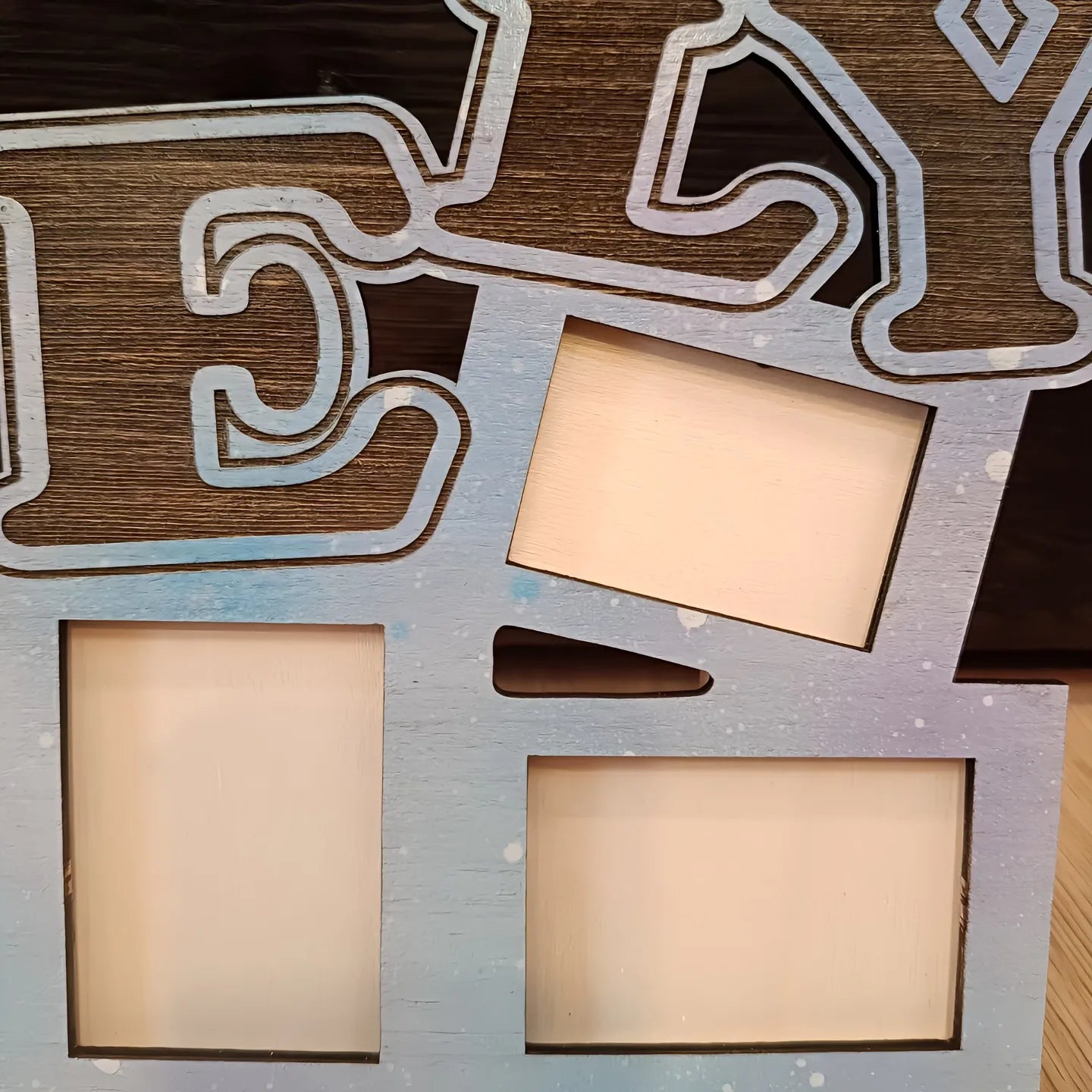 Wooden photo frame with blue paint, large letters, multiple empty rectangular slots