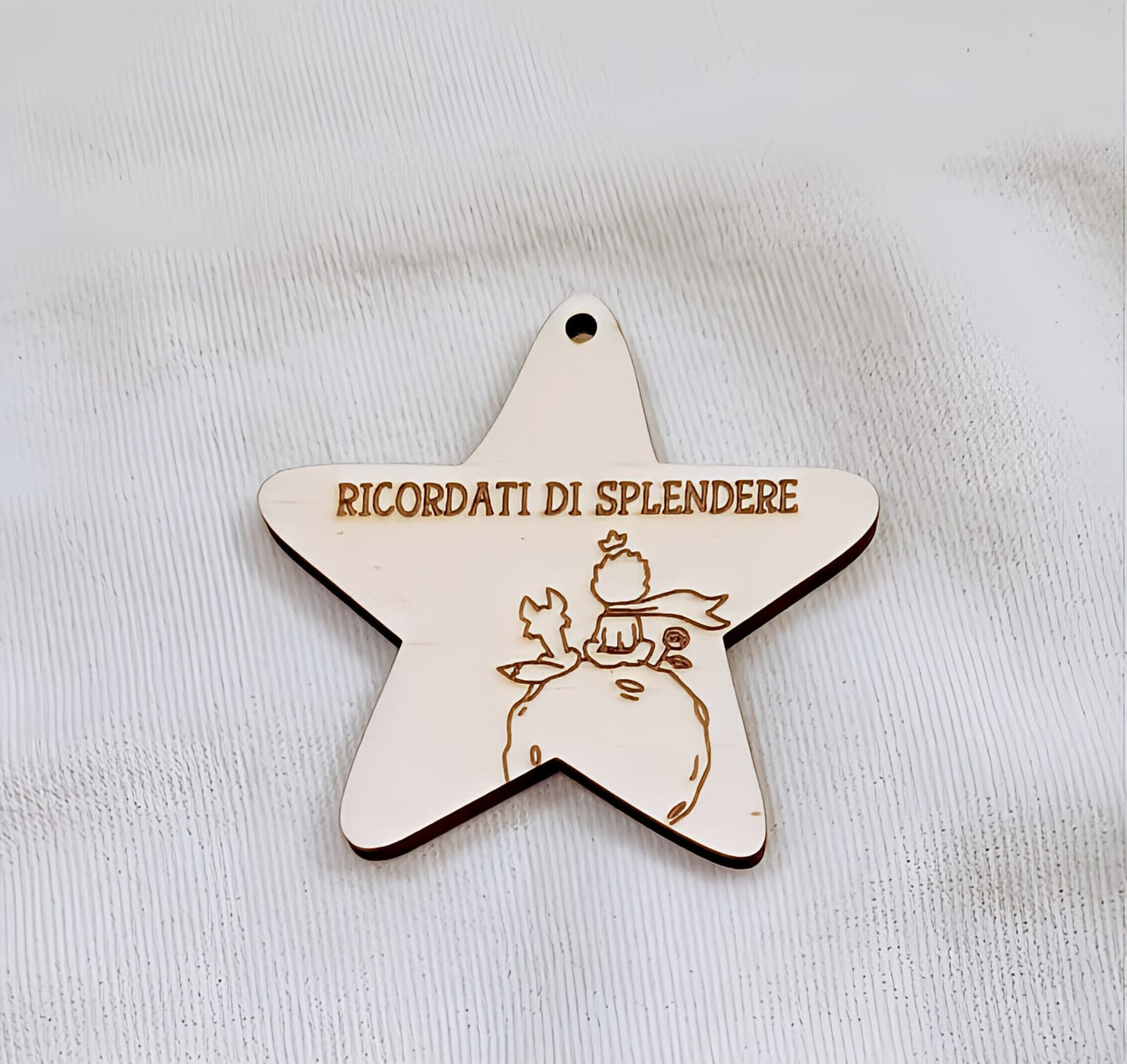 Wooden star-shaped ornament with Italian text and engraved illustration, on white background