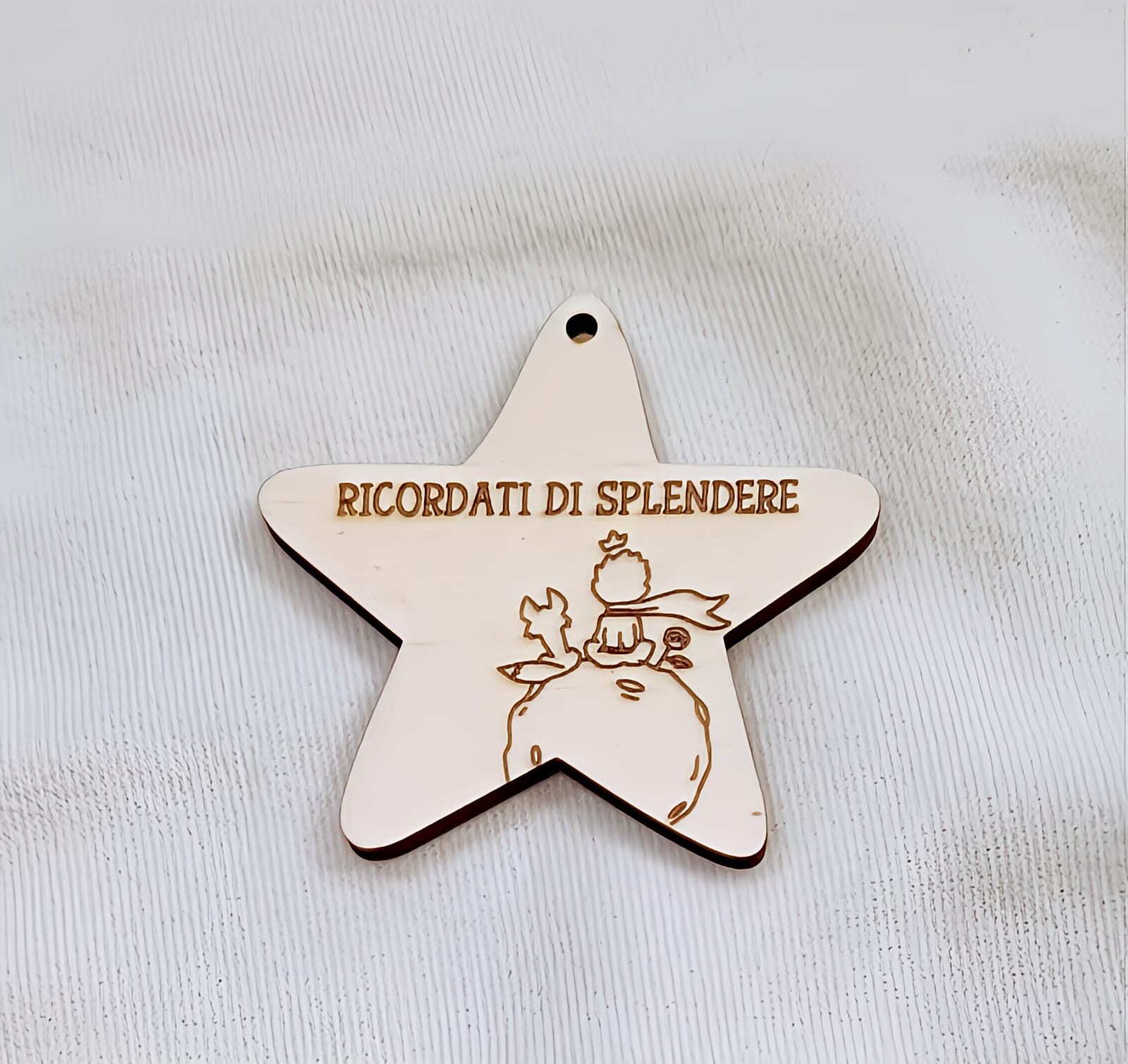 Wooden star-shaped ornament with Italian text and engraved illustration, on white background