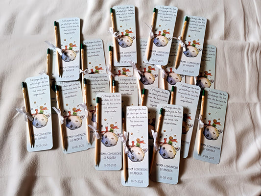 Little Prince themed communion bookmarks with attached pencils, arranged on a bed