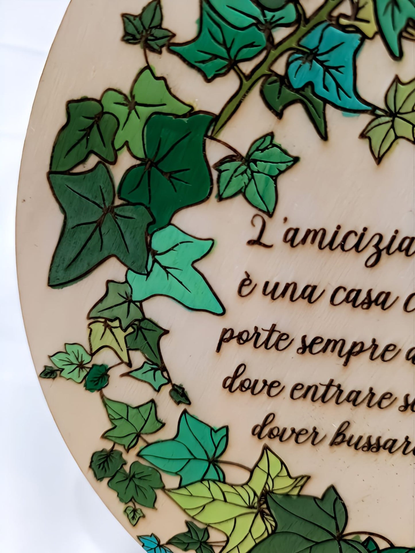 Decorative wooden plaque with colorful ivy leaves and Italian friendship quote engraving