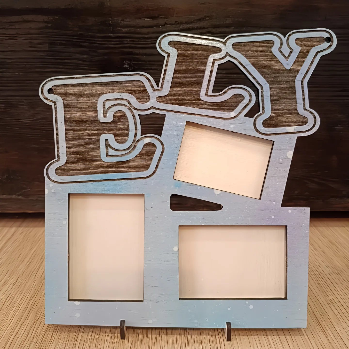 Wooden ELY photo frame with four empty slots on a light wood surface