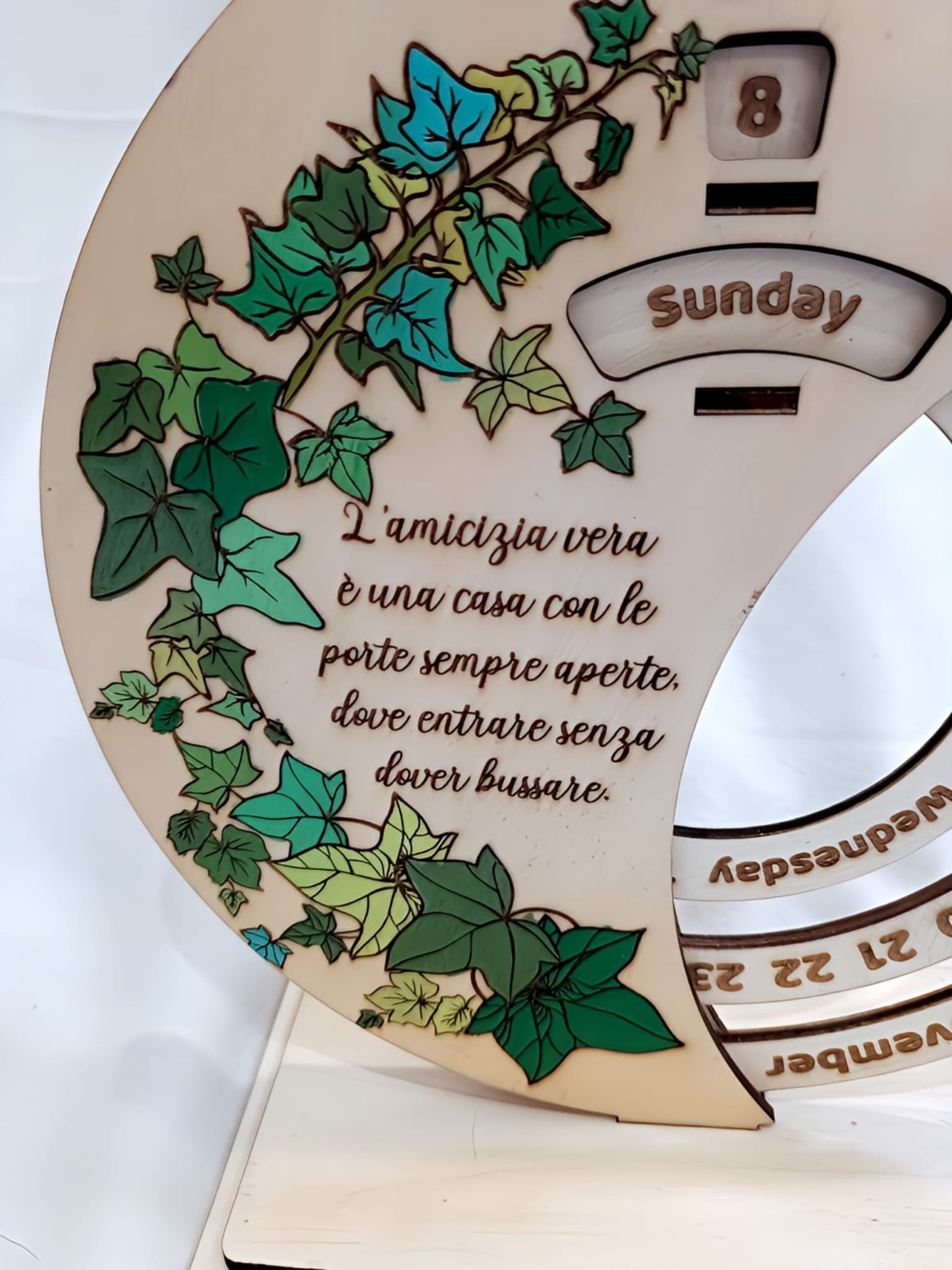 Wooden perpetual calendar with green ivy leaves and Italian friendship quote, Sunday highlighted