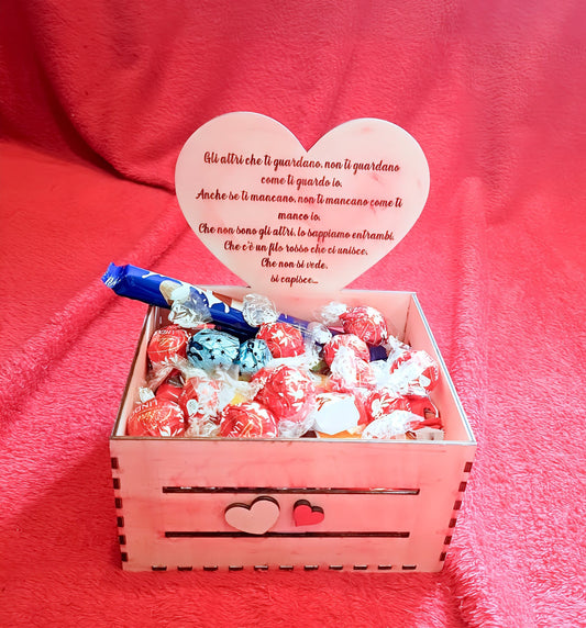Pink gift box with assorted Lindt chocolates, heart decoration, and Italian love message on pink fabric