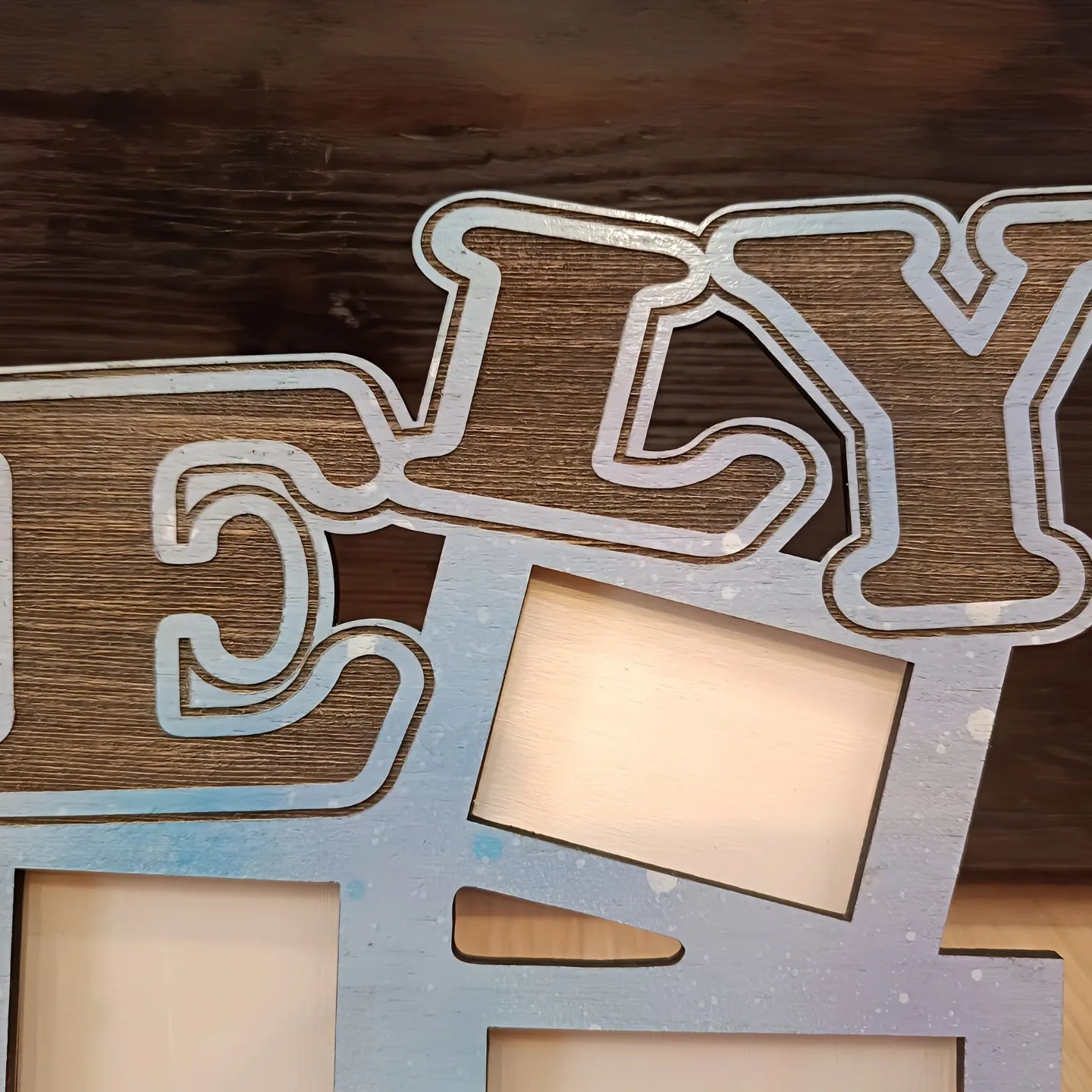 Close-up of wooden photo frame with large ELY letters, rustic wood background