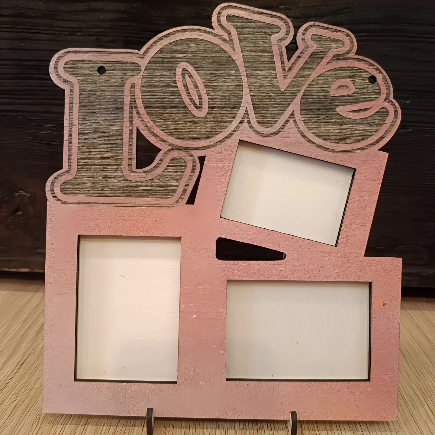 Wooden LOVE photo frame with three empty slots on a wood surface, rustic decor.
